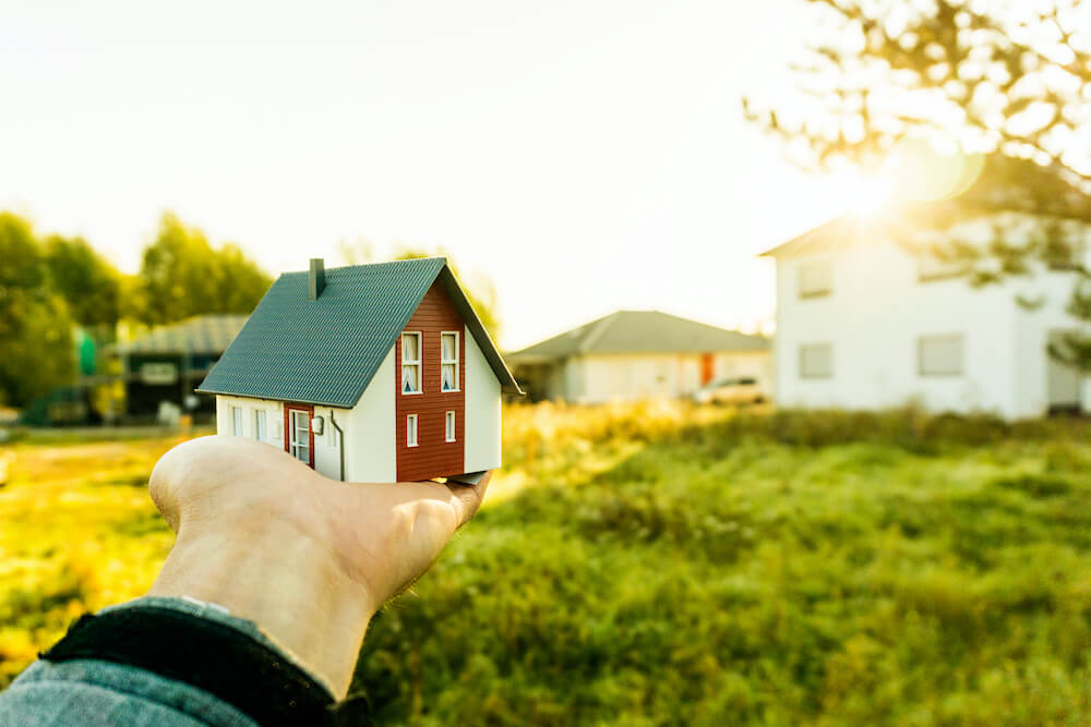 Hand hält Haus über Erbpachtgrundstück